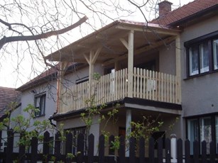 Dřevěná veranda s balkonem a zábradlím na rodinném domě Dřevěná veranda s balkonem a zábradlím na rodinném domě