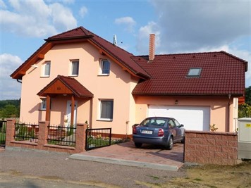 Rodinný dům s oranžovou fasádou a červenou taškovou střechou Rodinný dům s oranžovou fasádou a červenou taškovou střechou