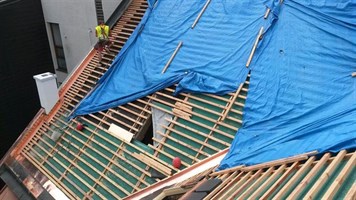 Rozpracovaná střecha s latěním a modrou fólií Rozpracovaná střecha s latěním a modrou fólií