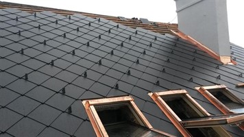Střešní okna v tmavé krytině vedle komína Střešní okna v tmavé krytině vedle komína