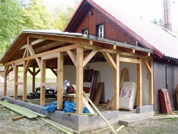 Tesařská konstrukce dřevěného přístřešku u domu s taškovou střechou Tesařská konstrukce dřevěného přístřešku u domu s taškovou střechou
